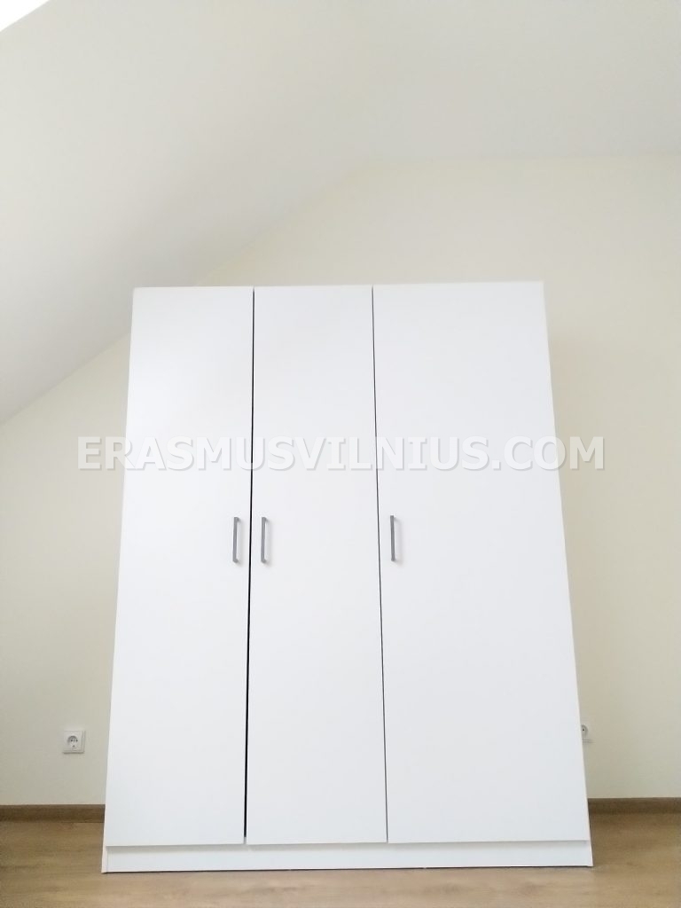 Vista completa della camera mansardata con soffitto inclinato e lucernario